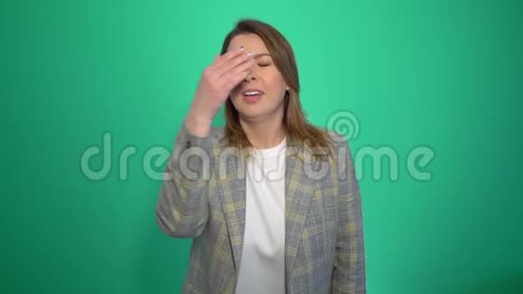 合上金发女郎在哭心烦意乱的哭泣的女人看着相机孤立在绿色背景上视频的预览图