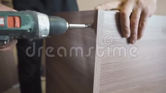 工人用螺丝刀和螺丝将木桌组装并拧开视频的预览图