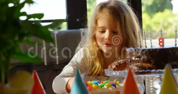 可爱的女孩准备在家装饰生日蛋糕4k视频的预览图