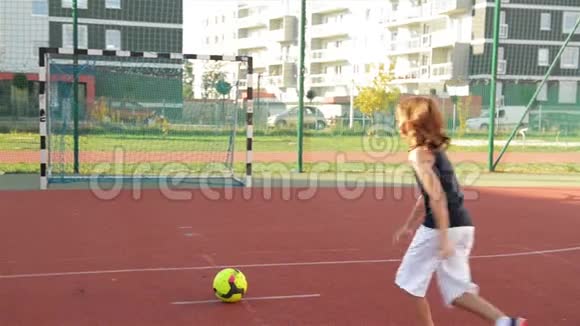 一个小男孩在点球大战中进球慢动作户外运动它健康生活的源泉视频的预览图