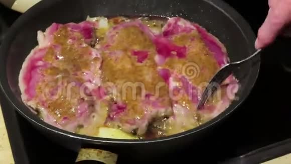 用芥末和胡椒等香料在平底锅中烤猪肉牛排视频的预览图