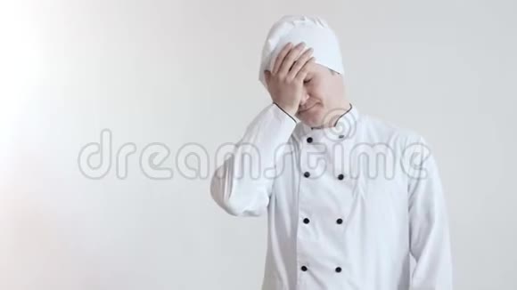 坐在厨师衣服上的沮丧的男人做了一个面部表情然后发牢骚从镜头里转过沮丧的目光视频的预览图