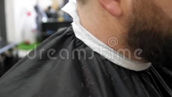 理发师用专业的胡须修剪在理发店的轻背景特写全高清视频的预览图