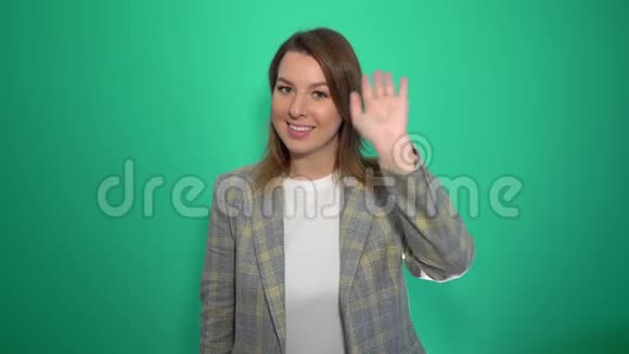 嗨你好女人挥手欢迎来到隔离的绿色背景视频的预览图