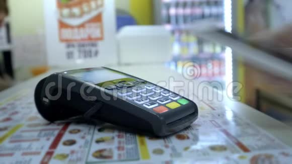 女性使用NFC技术通过智能手机支付特写镜头店内智能手机支付男子适用视频的预览图