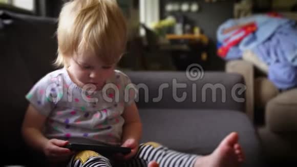 小女孩看着智能手机笑了视频的预览图