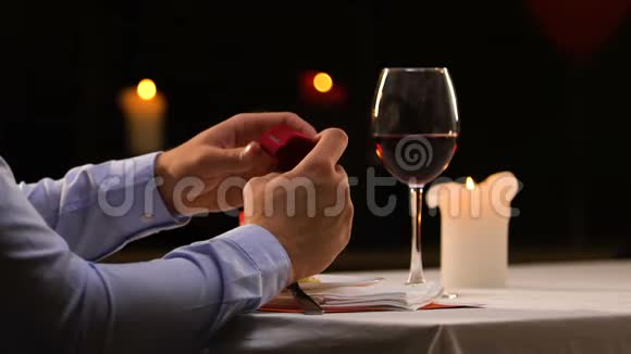 带着悲伤的男人看着结婚戒指把它放在桌子上然后离开视频的预览图