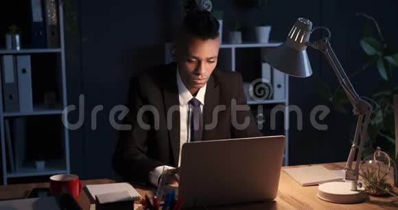 商人在晚上喝咖啡在笔记本电脑上工作视频的预览图