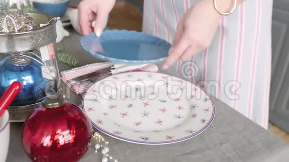 圣诞餐桌装饰节日餐桌设置女性的双手为圣诞节装饰餐桌视频的预览图