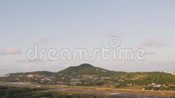 客机在天空中降落在群山和棕榈树的背景上一架波音客机飞过视频的预览图