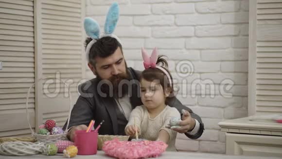 为复活节做准备的幸福家庭复活节彩蛋爸爸和他的小女儿在准备复活节假期时玩得很开心视频的预览图