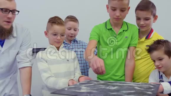 孩子们在实验室里看着Chladni盘子上跳舞的沙子视频的预览图
