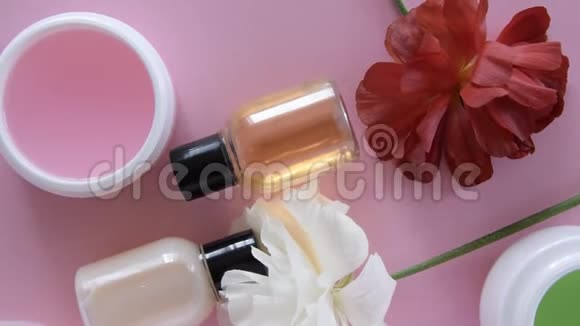 在新鲜的粉红色背景下可以看到不同的卫生化妆品产品和鲜花健康美容治疗视频的预览图