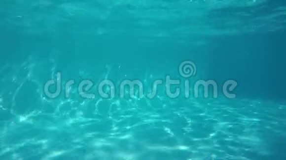 白人女孩在镜头前的泳池里奔跑从水下看视频的预览图