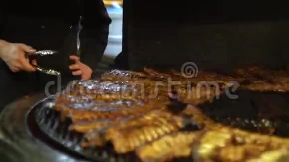 厨师把肉放在烤架上做烧烤香肠肉丝视频的预览图