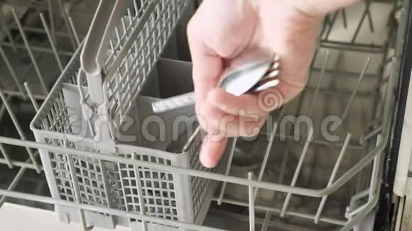 男人把脏盘子和餐具放进洗碗机里视频的预览图