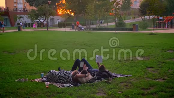 在公园里躺在草地上休息的青少年的特写镜头在户外看书放松视频的预览图