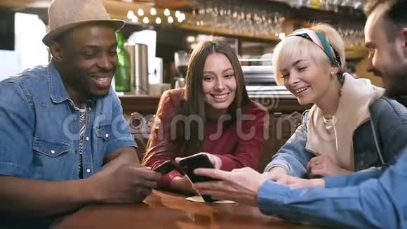 群快乐的hipster朋友一起看视频拍照在智能手机上一起在酒吧酒吧视频的预览图
