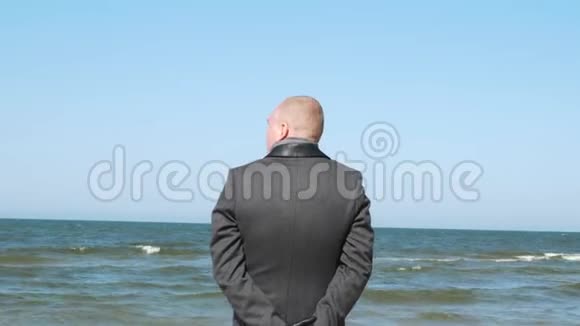 时髦的男人向你展示手势微笑和眨眼优雅自信的年轻商人在海滩上商务视频的预览图