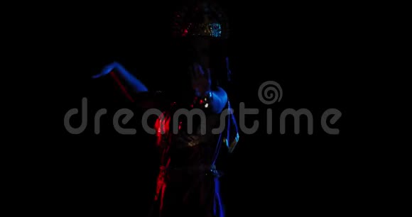 穿着传统服装和头饰的印度女人在五颜六色的灯光下跳舞视频的预览图