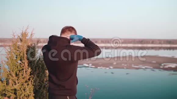 身穿连帽衫的运动员脱下连帽衫欣赏风景视频的预览图