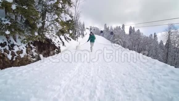 滑雪场娱乐活动朋友们在滑雪场玩得很开心金发爱抚西伯利亚哈士奇的年轻女孩视频的预览图