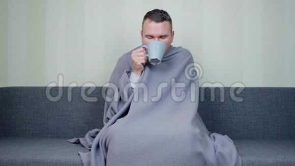 裹着毯子的病人喝一杯热茶视频的预览图