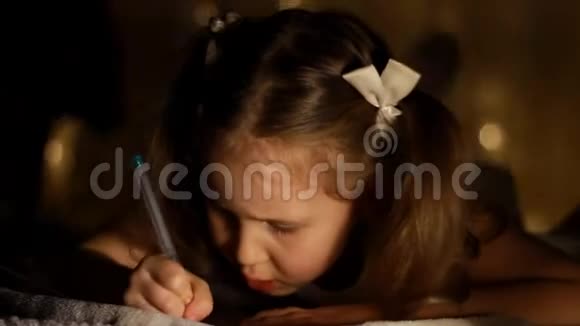 孩子们正在房间里写一封信给圣诞老人晚上在灯光下为圣诞节做准备假期视频的预览图