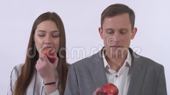 特写照片年轻夫妇吃红苹果女人在跳舞男人如此快乐笑容被孤立在白色背景上视频的预览图