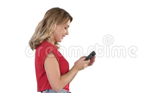 快乐可爱漂亮的年轻女人在白色背景上用手机玩游戏视频的预览图