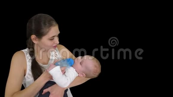 母亲抱着婴儿从阿尔法频道的瓶子里喂奶视频的预览图