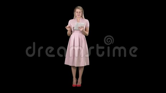 漂亮迷人自信时尚的粉红色女士手里拿着平板电脑看着相机翻页或皱褶视频的预览图