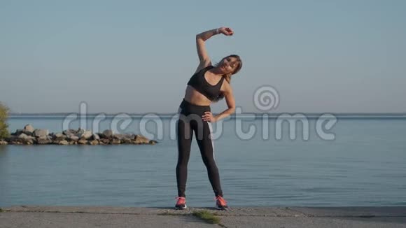 在海滨慢跑的晚上运动的女孩正在热身视频的预览图