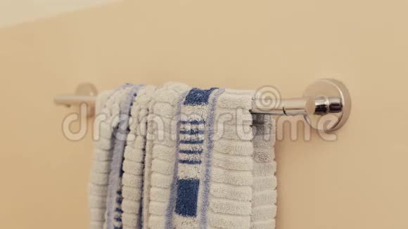 男人从浴室的衣架上拿出毛巾视频的预览图