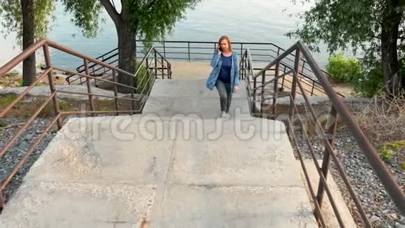 一个女人从河岸走上楼梯视频的预览图