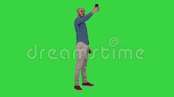 自拍时间英俊的年轻人用手机在绿色屏幕上自拍Chroma键视频的预览图