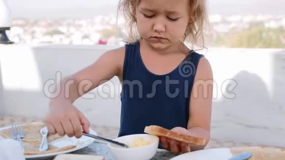 小女孩正在用黄油做三明治作为早餐视频的预览图