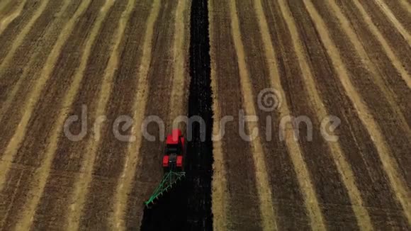后视红色拖拉机耕田准备播种土地空中观景农民在拖拉机上准备土地视频的预览图