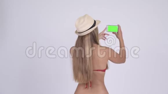 年轻的金发碧眼旅游妇女带着电话拍照后景视频的预览图