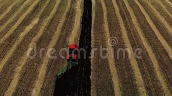 后视红色拖拉机耕田准备播种土地空中观景农民在拖拉机上准备土地视频的预览图