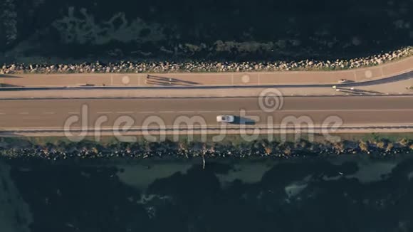 傍晚汽车人和骑自行车的人在海上沿着大坝前进意大利奥贝泰洛视频的预览图