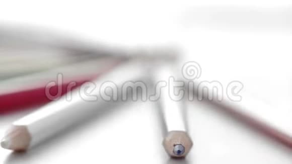 极端特写方向彩色铅笔躺在白色的桌子上视频的预览图