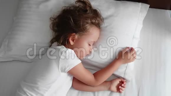 小可爱的女孩早上醒来在床上伸展身体视频的预览图