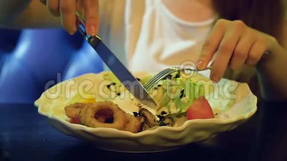 年轻女子在豪华餐厅吃新鲜沙拉女孩用刀叉切鸡蛋视频的预览图