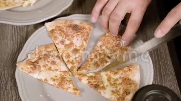 男人用刀把披萨切成碎片上景视频的预览图