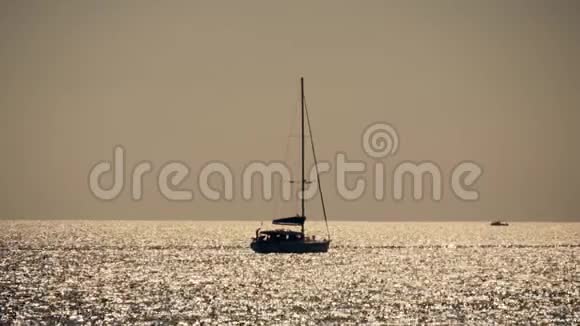 在夕阳的阳光下帆船在海上航行海上帆船的剪影活跃在海上休息视频的预览图