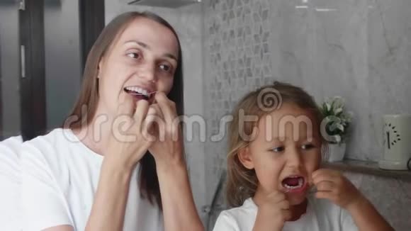 妈妈和小女儿一起在浴室用牙线刷牙视频的预览图