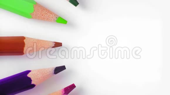特写俯视图一排彩色铅笔在白色桌子上的圆圈周围慢慢旋转视频的预览图