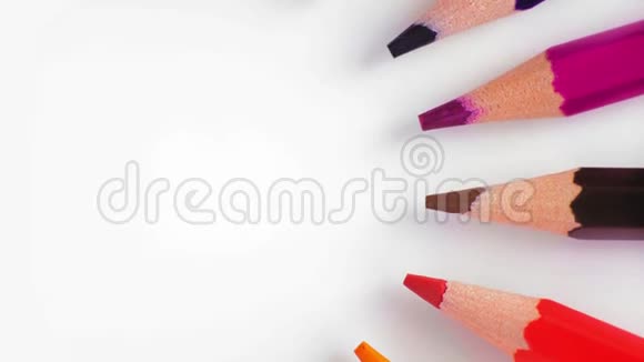 特写俯视图一排彩色铅笔在白色桌子上慢慢向右旋转视频的预览图
