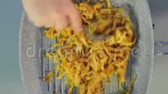 一个女人把米粉混合在平底锅里把鸡肉和蔬菜加在里面视频的预览图